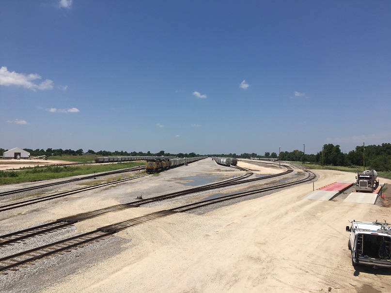 Trucks and trains are positioned to move frac sand at the new Loup railport in El Reno, Oklahoma.